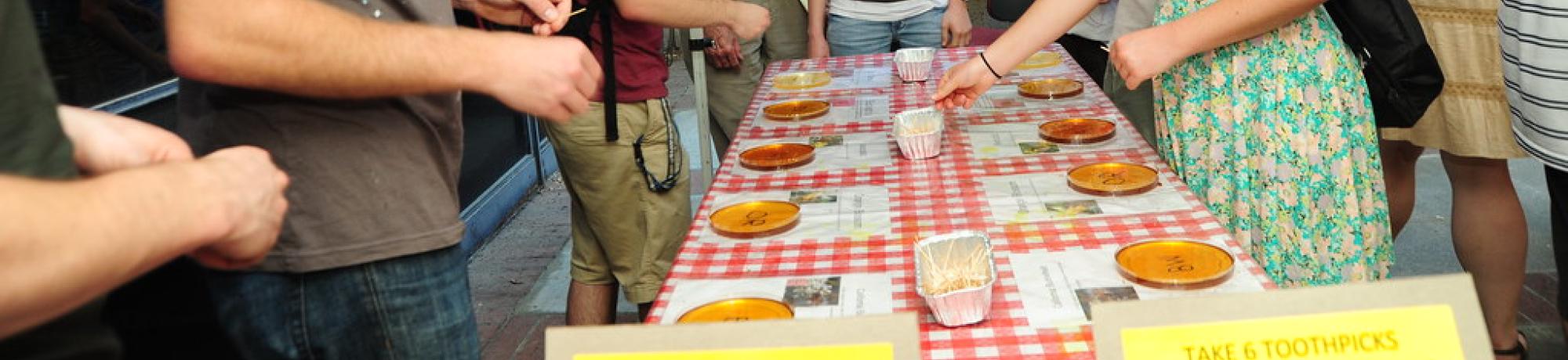 Group of people around table honey tasting